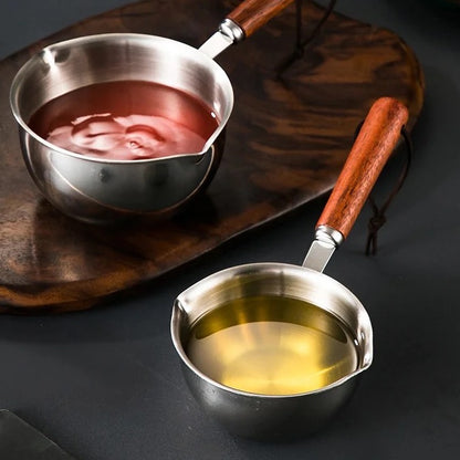 Two stainless steel pots with wooden handles